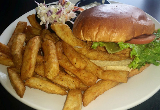 Enjoy a Fried Haddock Sandwich that is served on a brioche roll with lettuce and tomato