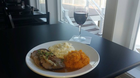 Enjoy a pork dinner with a choice of two sides and a glass of wine