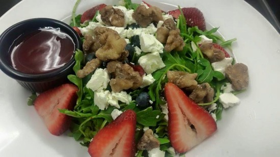 The Baby Arugula Salad at 308 Lakeside comes with Candied walnuts, strawberries, blueberries, feta cheese and light raspberry vinaigrette.